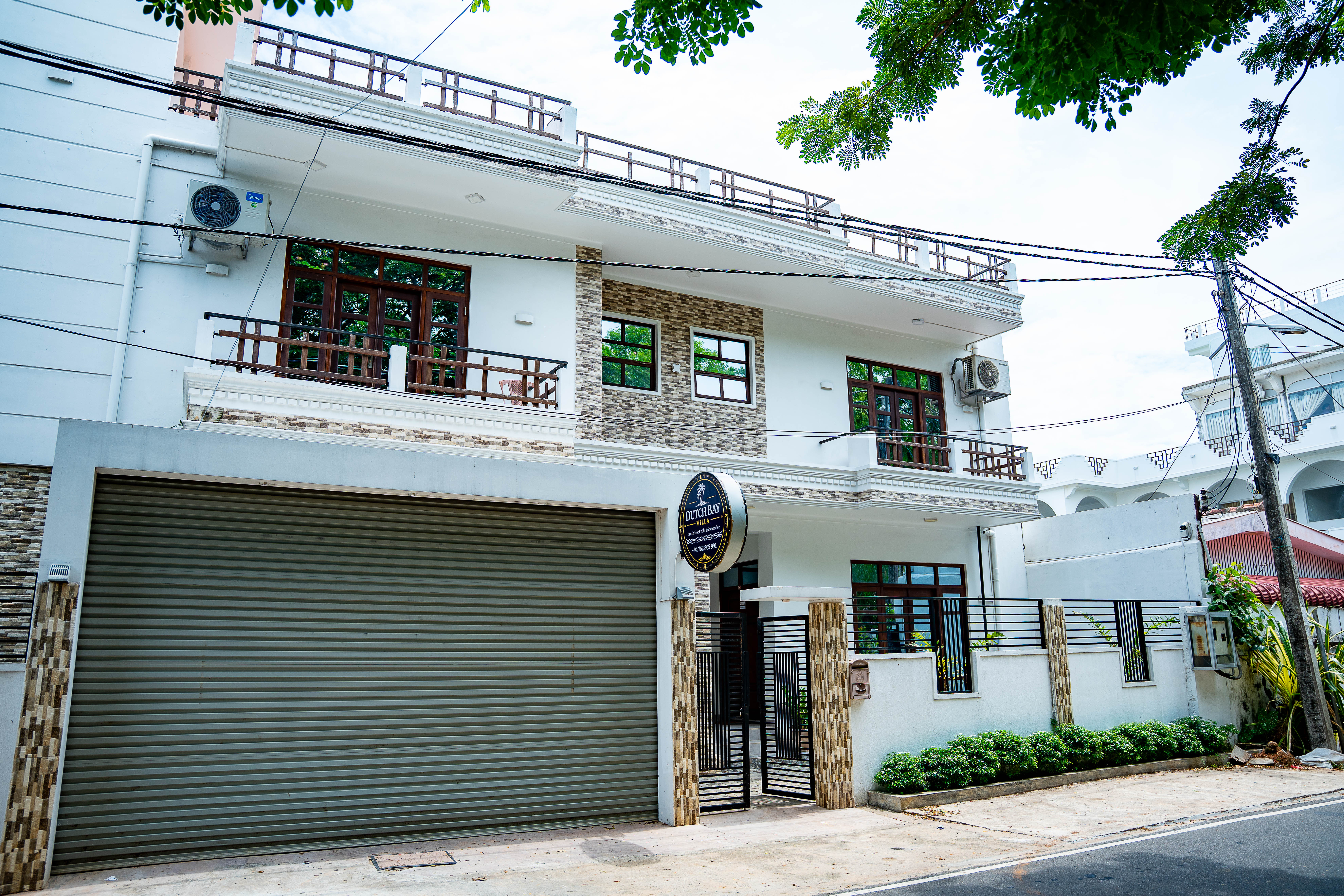 Street facade with round Dutch Bay Villa sign